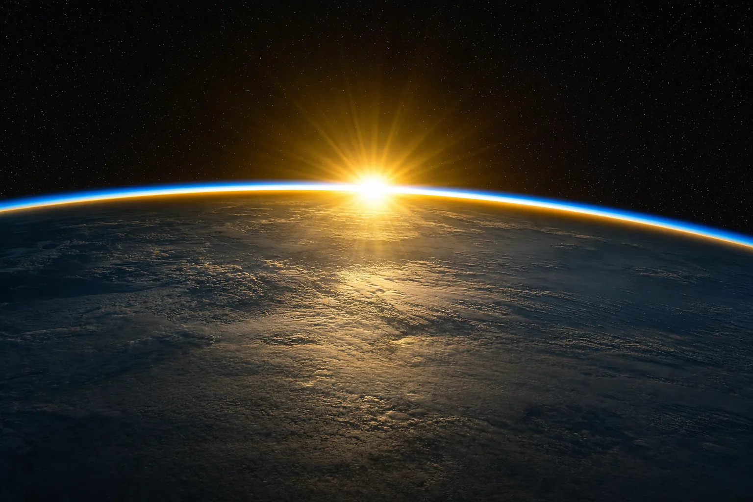 The curved limb of Earth at orbital sunrise — a thin glowing line of atmosphere against black space